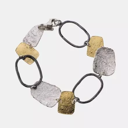 Bracelet composed of textured rectangular links and gilded, white and darkened silver rings 