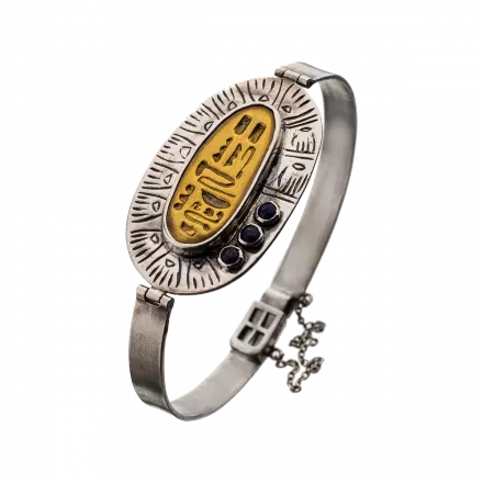 Silver Bangle with stunning center silver oval with brass piece engraved with an ancient Egyptian decoration and decorated with lapis stones